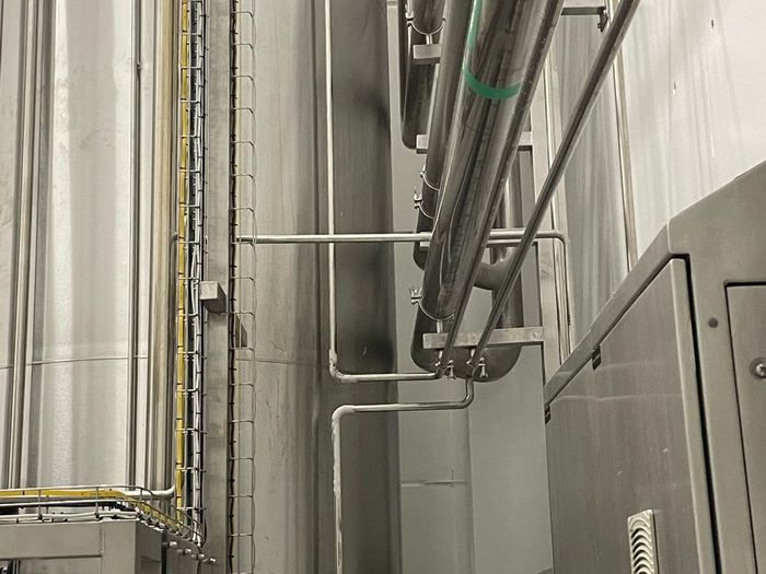 Tanques e tubulação de sistema CIP em planta de alimentos